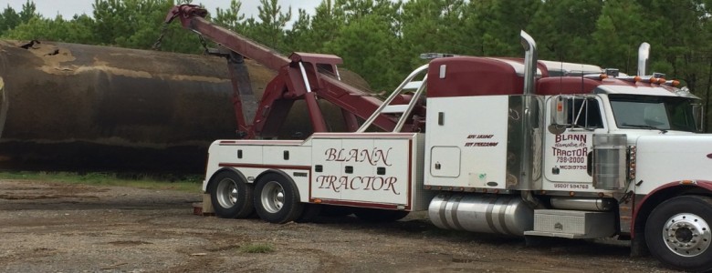 Wrecker truck holding a huge metal object on the tow